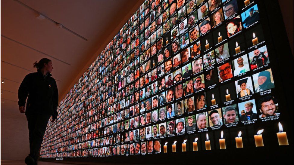A visitor looks at a giant backlight screen bearing the portraits of the Israeli people who were killed during the October 7 attacks by Hamas in southern Israel or those who died during the ongoing battles between Israel and the Palestinian militant group Hamas in Gaza, at the National Library in Jerusalem, on January 25, 2024