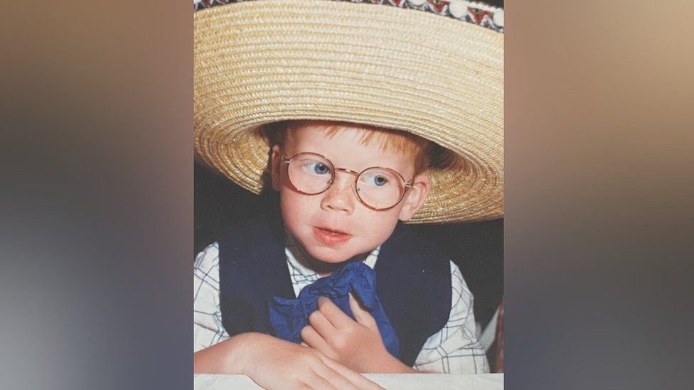 Luke as a child wearing a hat
