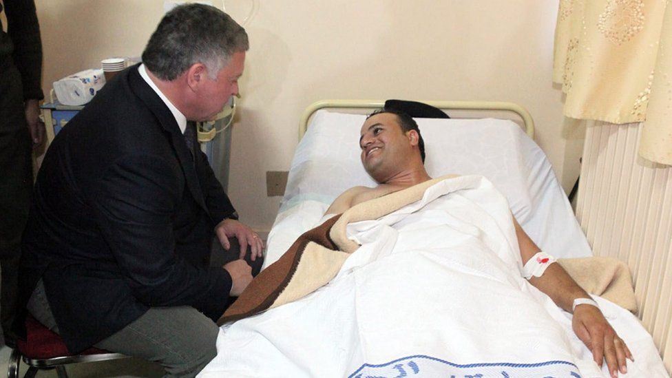 Jordan King Abdullah II, (L) visiting the injured victims of the shooting at the police training centre in hospital in Amman on 9 November 2015