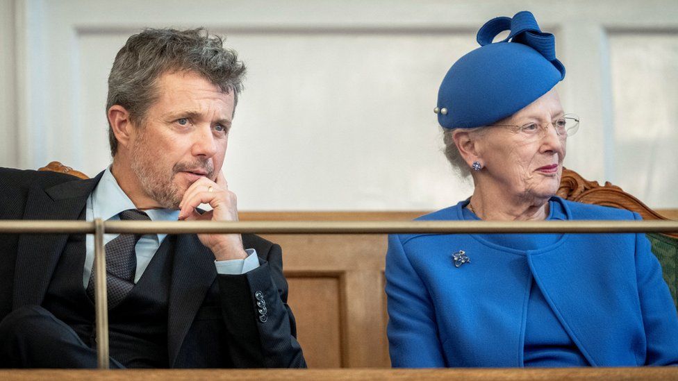 Queen Margrethe II and Crown Prince Frederik sit side-by-side at an event