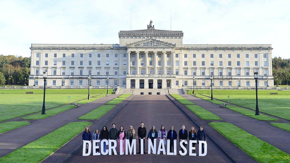 Pro-choice campaigners stand behind letter spelling the word decriminalised