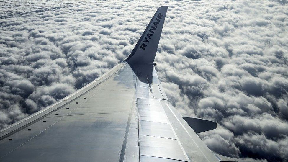 Ryanair wing above flying above clouds