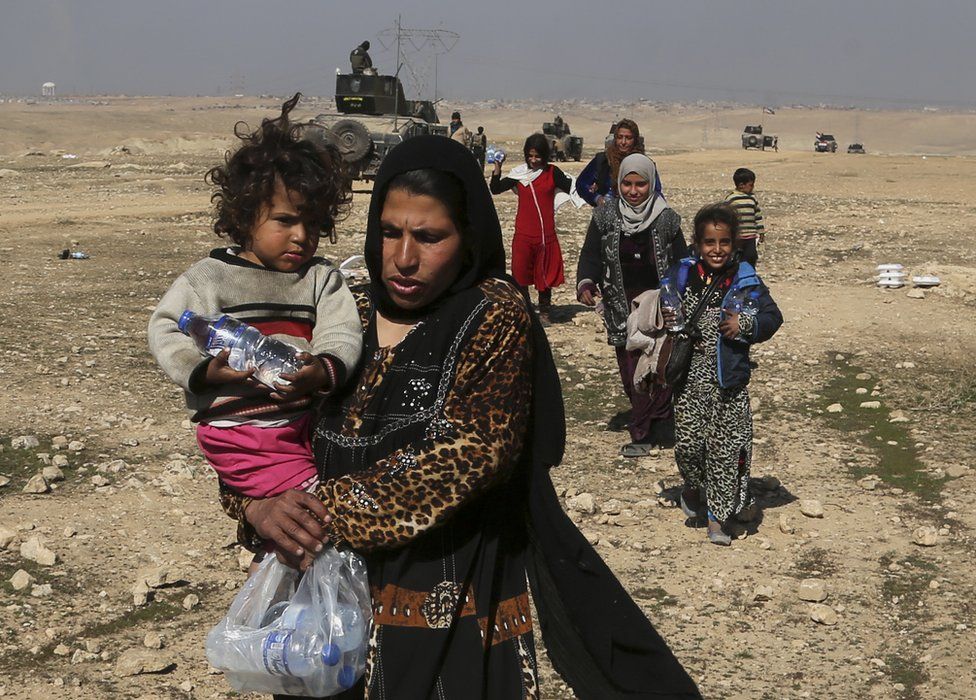 Displaced Iraqis flee their home near the western side of Mosul, 23 February