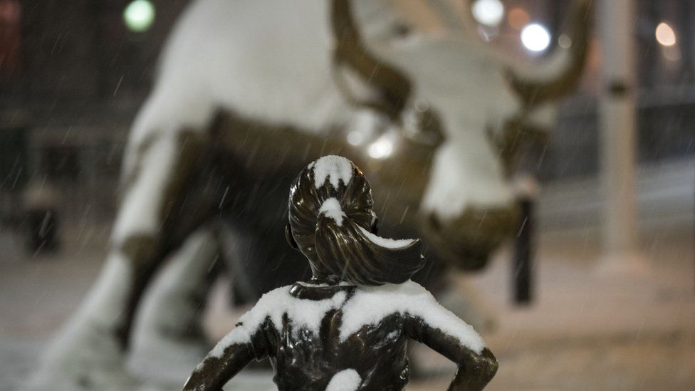 Wall Street bull and girl statue, covered in snow
