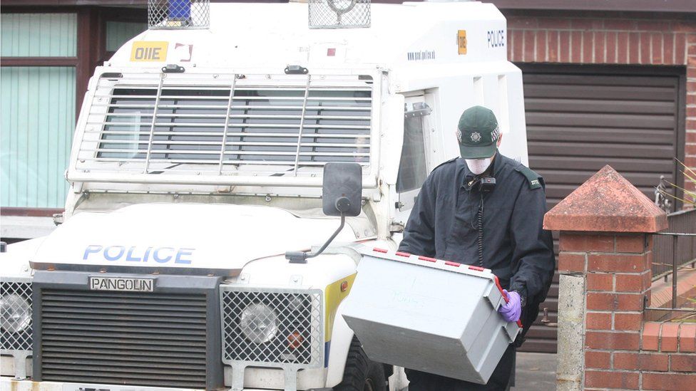 A police officer at the search of a house in wets Belfast in connection with the arrests