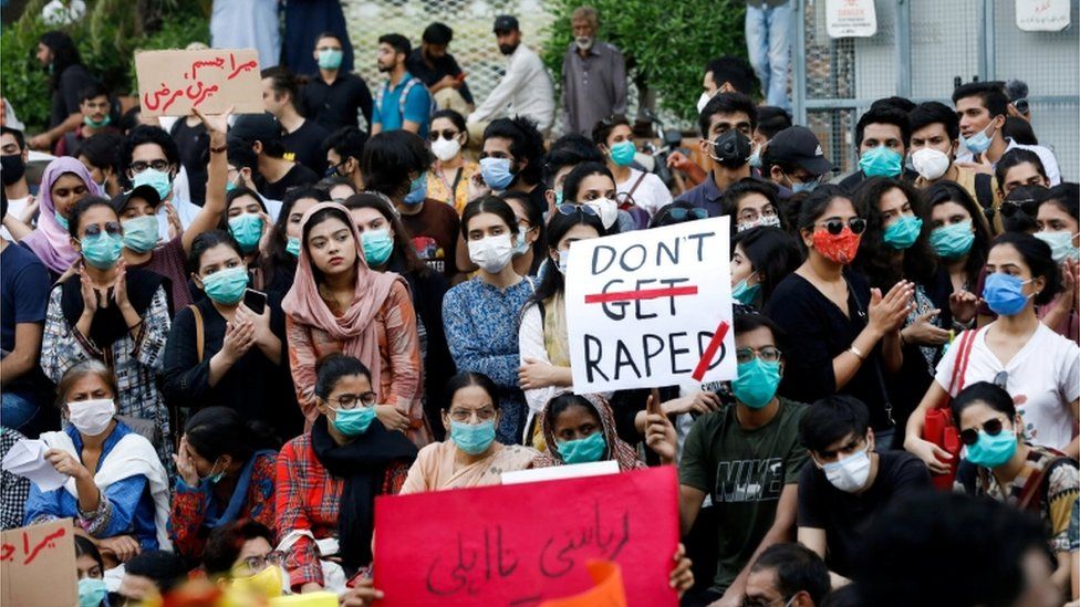 Women holding signs saying 'don't rape' at a protest