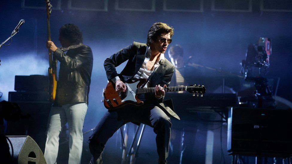 Arctic Monkeys frontman Alex Turner performing on stage