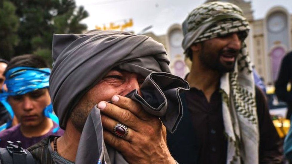 A man cries as he watches fellow Afghans get wounded by Taliban fighters outside Kabul Airport