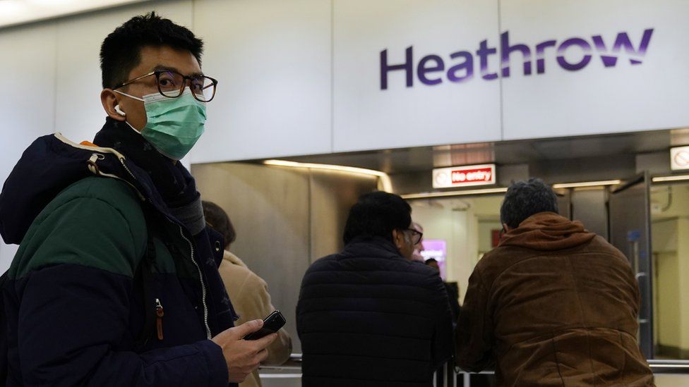 Photo from 22 January of a passenger wearing a mask when arriving at Terminal 4 of Heathrow Airport, London