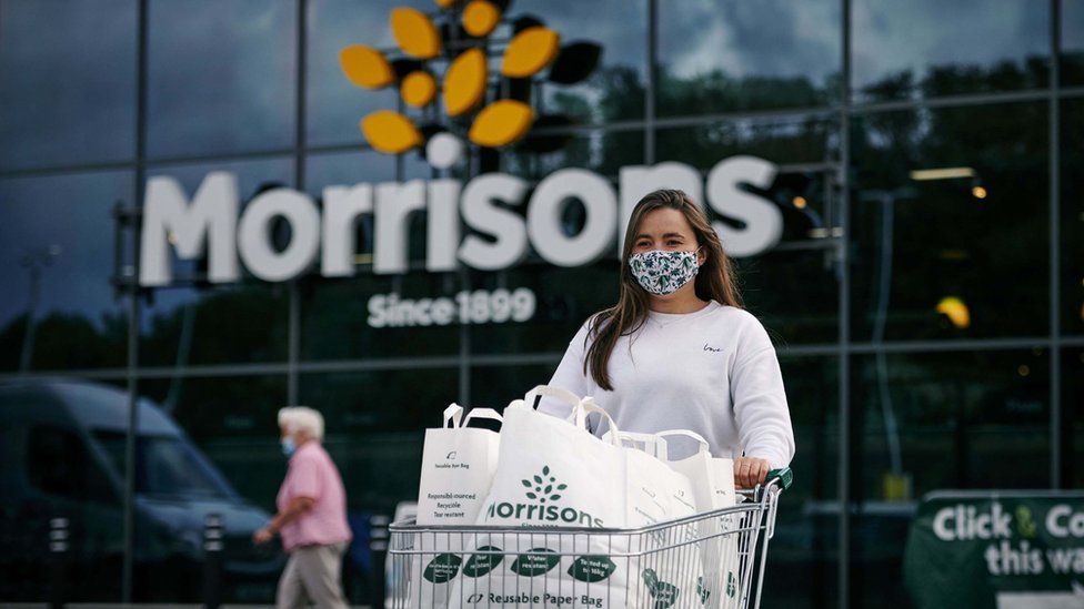 A woman with a supermarket trolley outside Morrisons