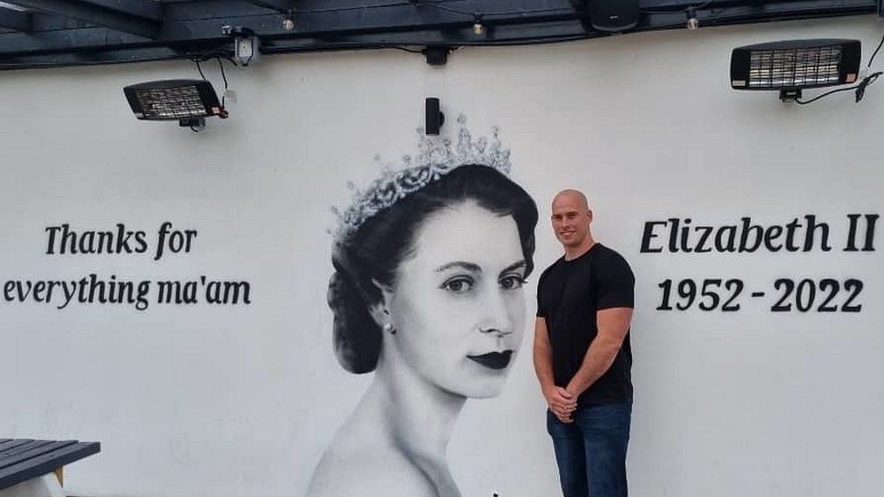 Artist Snow Graffiti with his mural paying tribute to the Queen