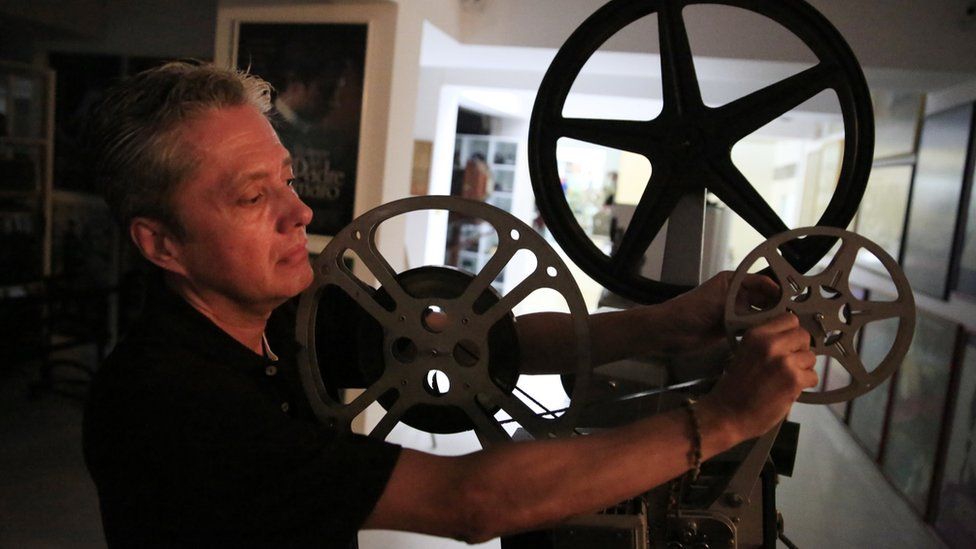 Santiago Cardenas with a vintage projector at the Caliwood Museum