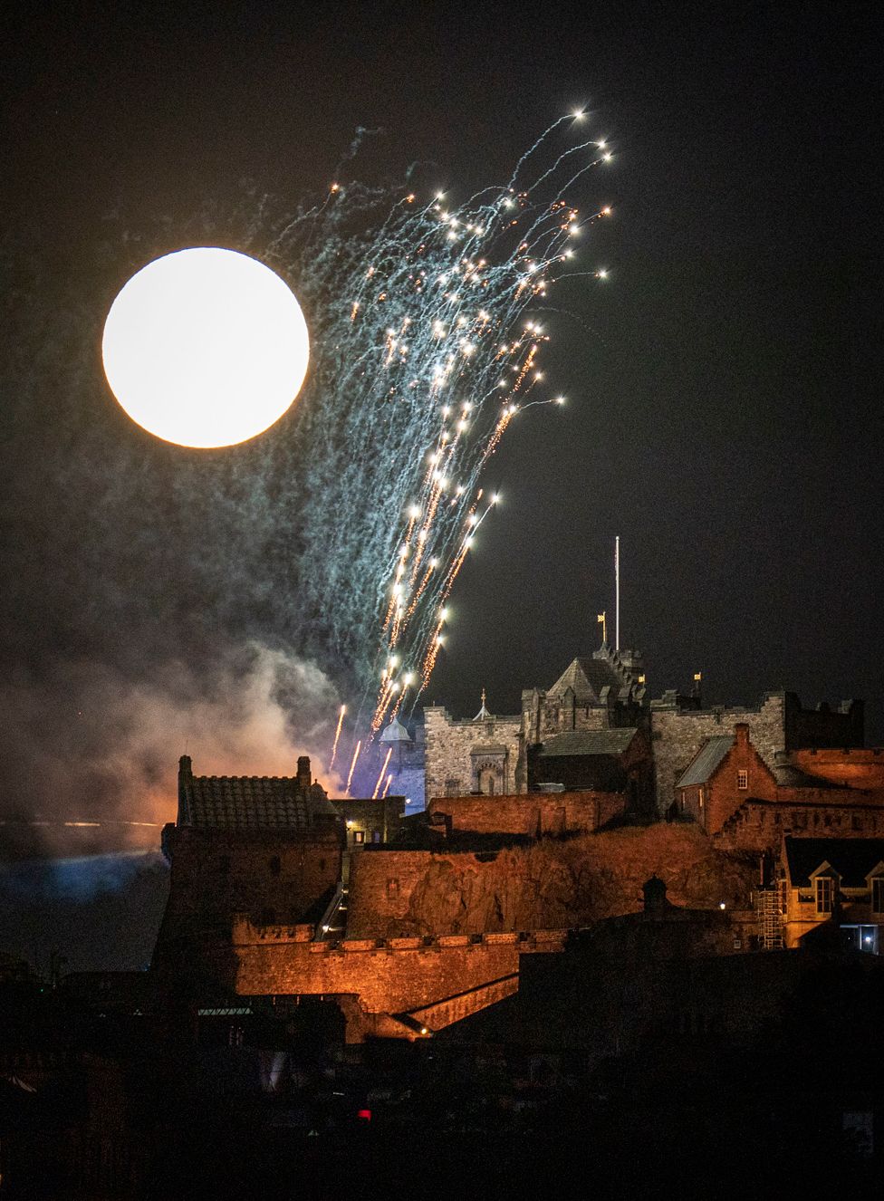 The moon shines behind Edinburgh Castle during the Royal Edinburgh Military Tattoo fireworks display