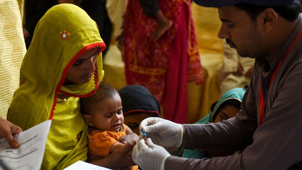 A mother holds her child, who is tested for HIV