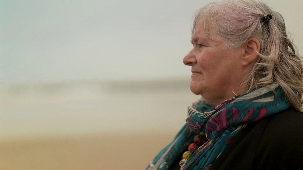 Woman at a beach staring away from camera