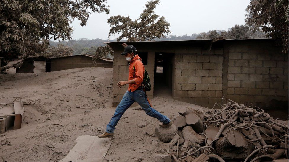 A man steps through debris in an area affected by eruption from Fuego volcano in the community of San Miguel Los Lotes in Escuintla, Guatemala June 4, 2018