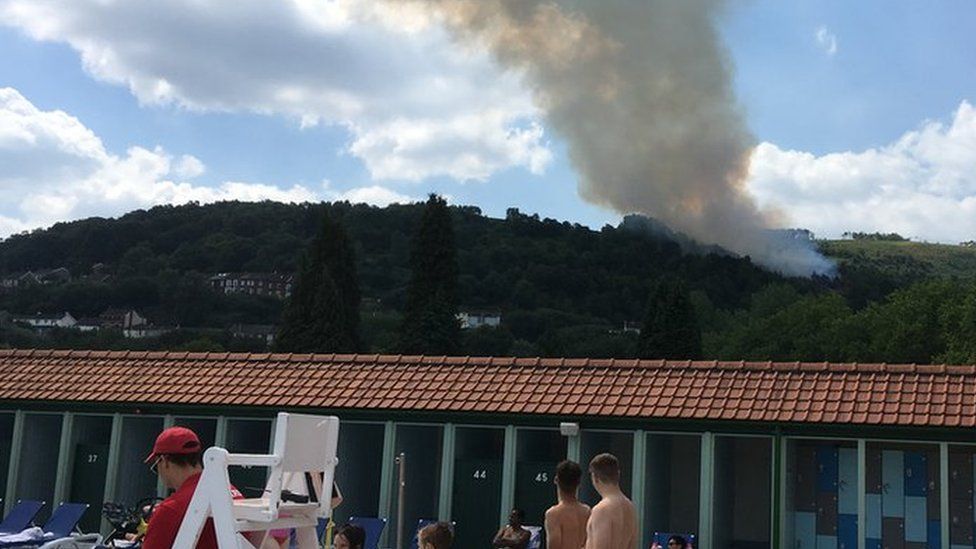 Fire in the hills above an ooutdoor swimming pool