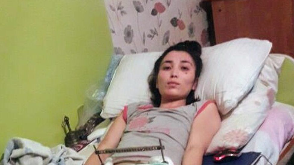 Saina Raisova on the bed after she was discharged from the hospital