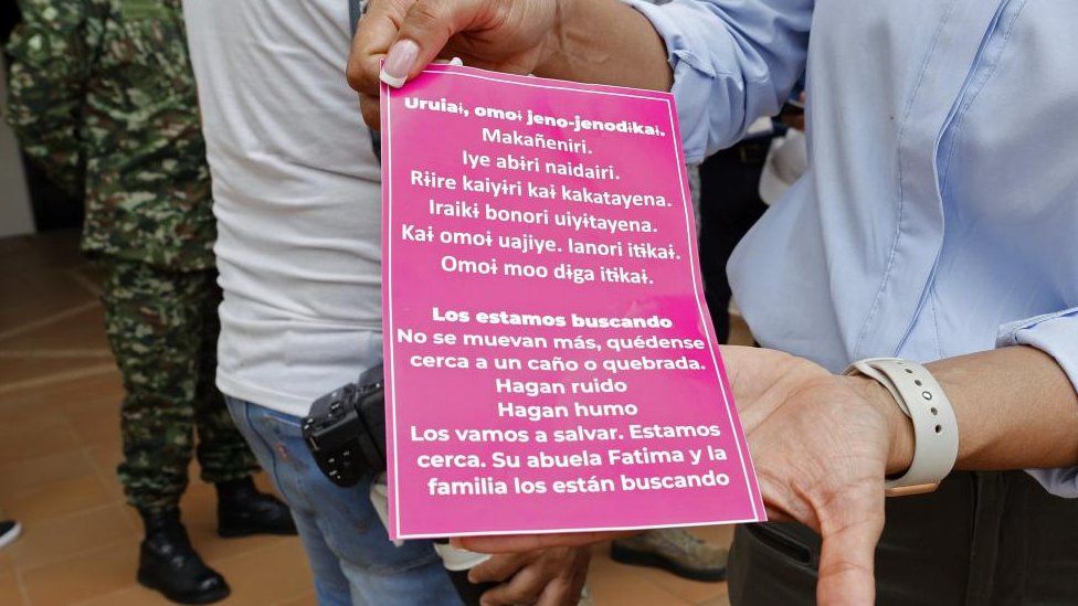 A person shows a poster in the Uitoto language, native to the Mukutuy children, and in Spanish, with a message about the minors lost for 20 days after a plane crash in southern Colombia, prior to a group of soldiers going to to the search area, from the Twenty-second Jungle Brigade in San Jose del Guaviare, Colombia, 20 May 2023.