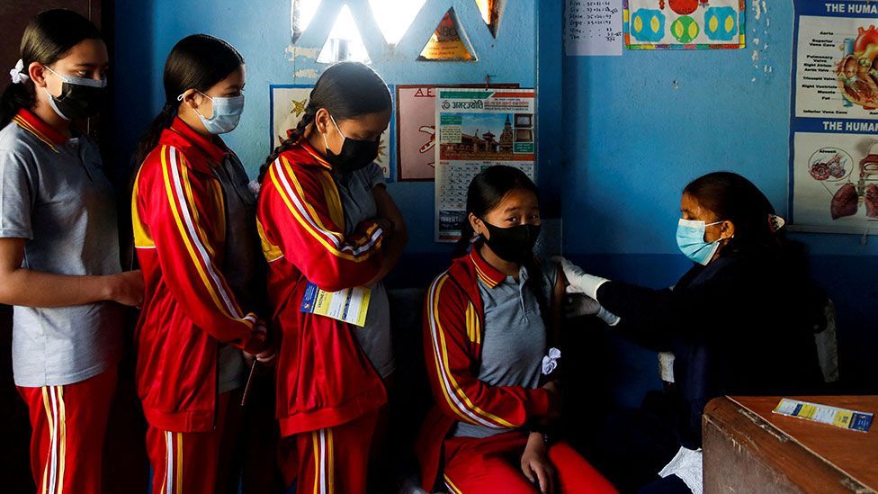Girls receive the coronavirus vaccine in Nepal