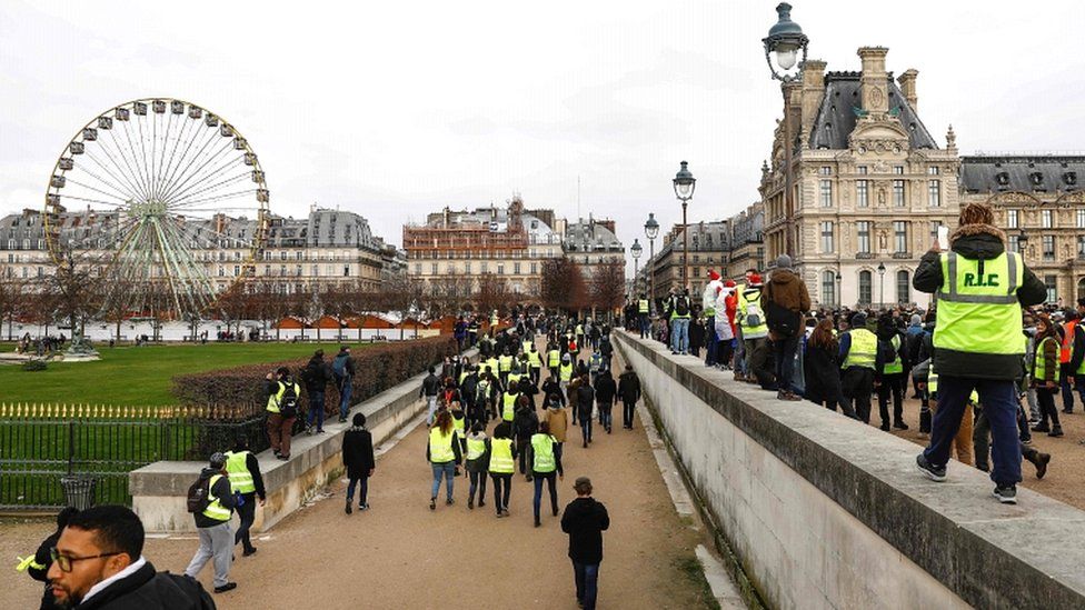 Yellow Vest protesters walk in the Jardin des Tuileries in Paris on 22 December 2018
