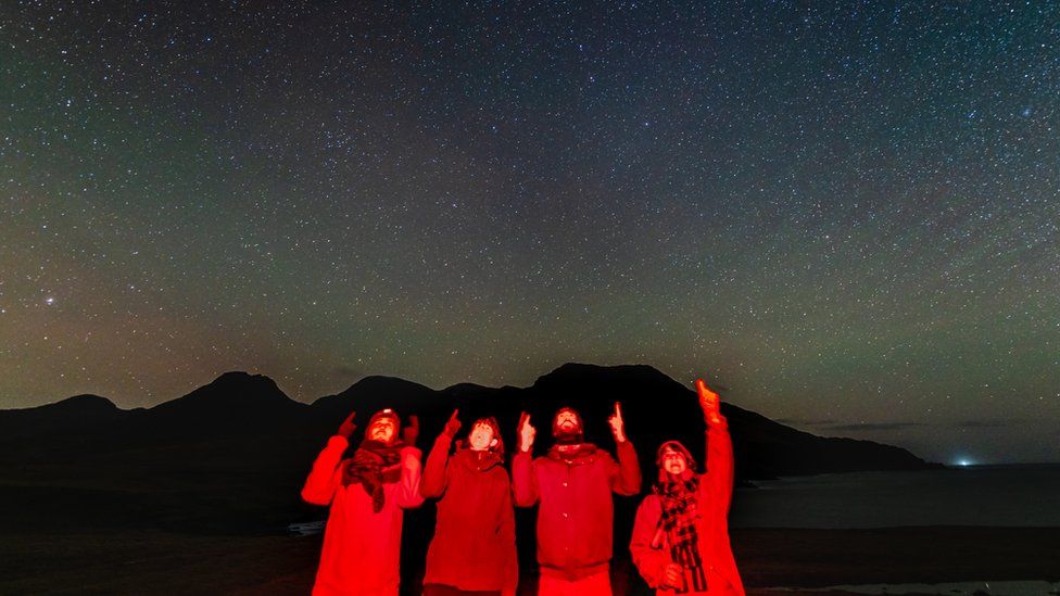 Residents on Isle of Rum pointing to starry sky