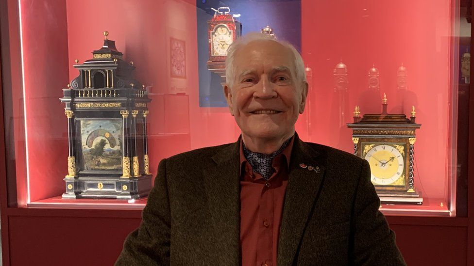 Dr John Taylor in front of a case in the exhibition