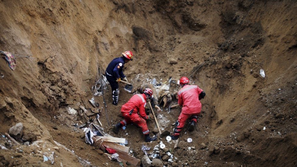 A rescue team recovers the body of a mudslide victim in Santa Catarina Pinula, on the outskirts of Guatemala City, October 3, 2015.