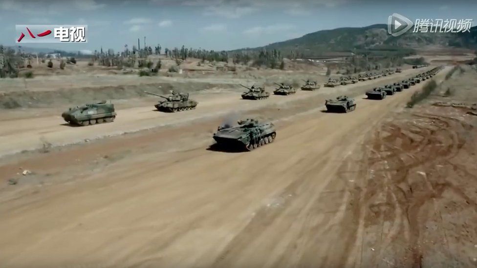 Two lines of tanks driving towards the camera