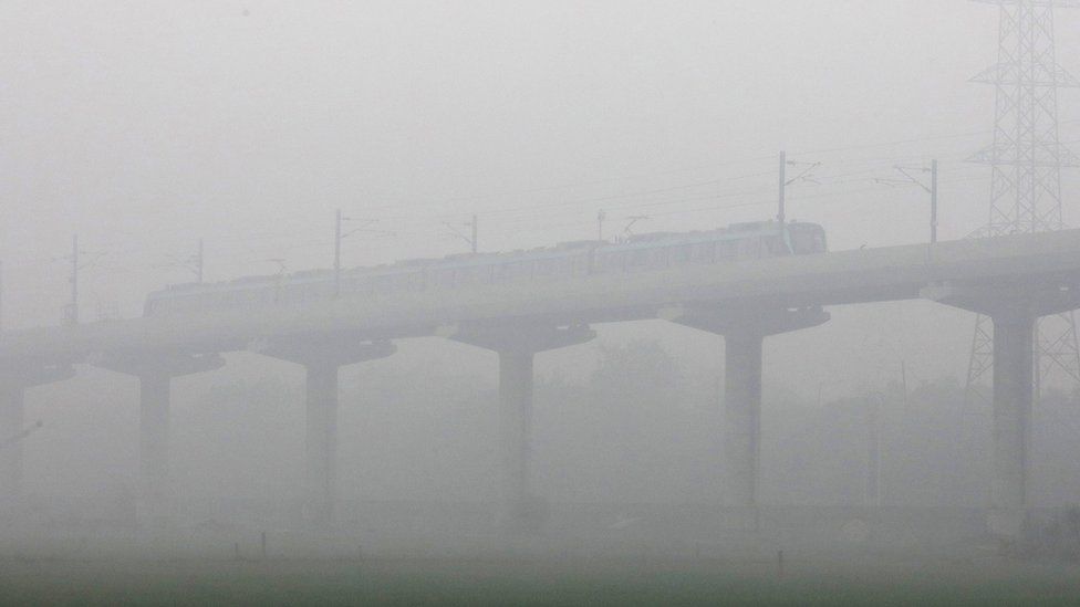 A train moves amid dense fog near Delhi on 30 January