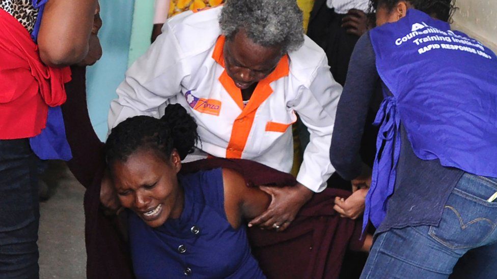 A relative is comforted by emergency medical staff at Moi Girls School in Nairobi, after a fatal pre-dawn blaze gutted one of the boarding facilities at the school leading to several deaths, 2 September 2017