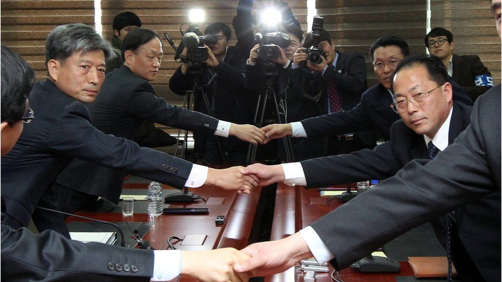 South and North Korean representatives to inter-Korean talks shake hands at the start of their meeting in the border city of Kaesong, North Korea, 11 December 2015