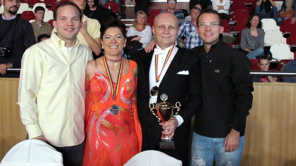 Florin and Mariuca Talpes celebrating winning a ballroom dancing trophy with their sons