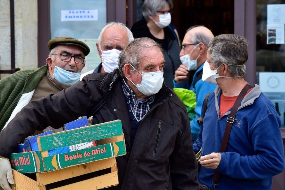 A man wearing a protective masks walks out of a Chanel store on its  reopening on the Champs Elysee avenue in Paris, France on May 11, 2020.  France began a gradual easing