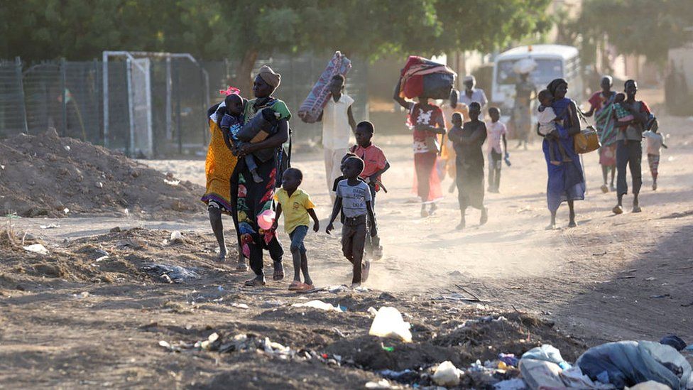 People flee their neighbourhoods amid fighting between the army and paramilitaries in Khartoum, 19 April 2023