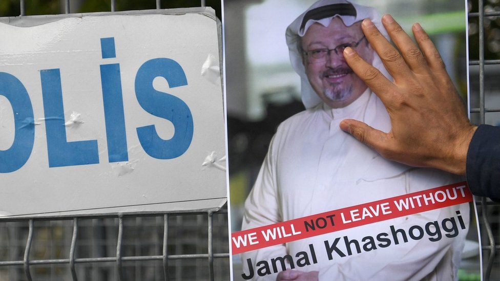 A man puts his hand over a poster of Jamal Khashoggi