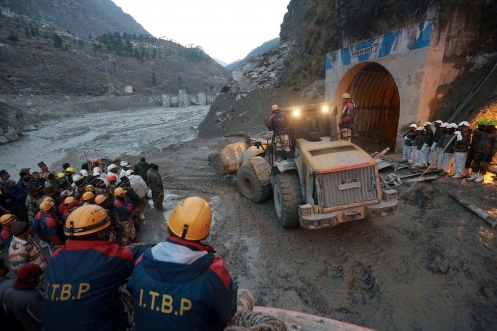 Members of Indo-Tibetan Border Police (ITBP) watch as a machine is used to clear a tunnel after a part of a glacier broke away, in Tapovan in the northern state of Uttarakhand, India, February 8, 2021