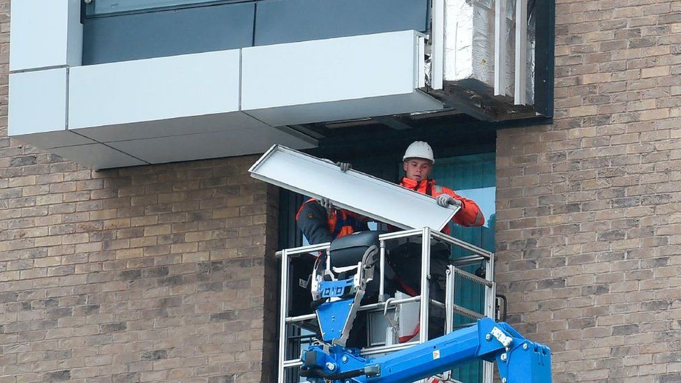 Рабочие снимают внешнюю облицовку здания в Манчестере после испытаний на пожарную безопасность после трагедии в башне Гренфелл