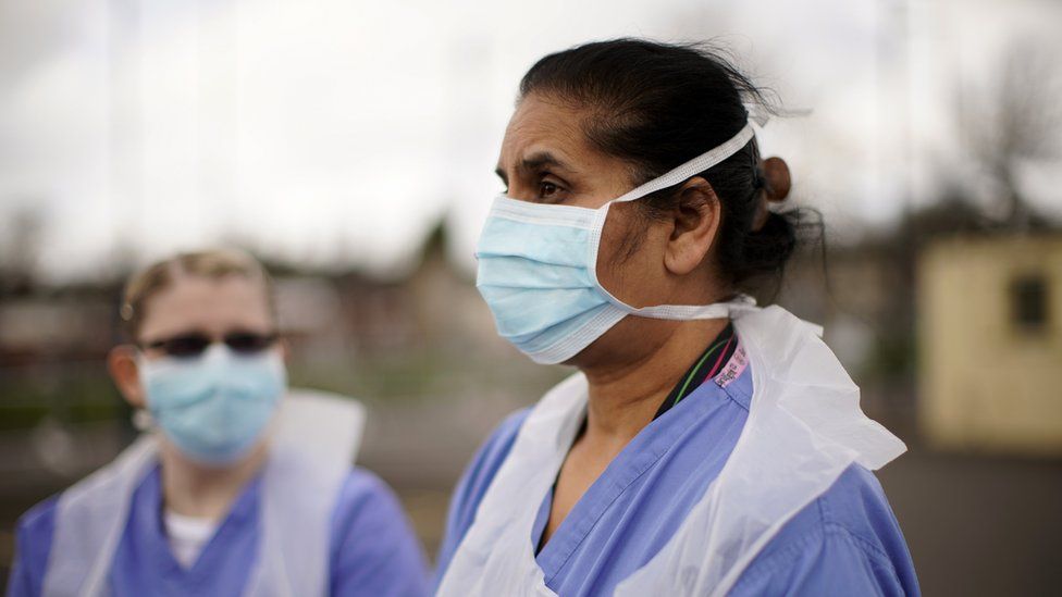 NHS nurses speak to the media as they wait for the next patient at a drive through Coronavirus testing site on March 12, 2020