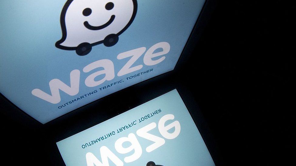 The logo of mobile app 'Waze' is displayed on a tablet