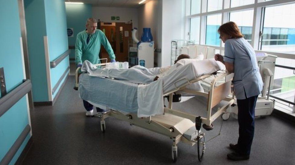 Nursing staff with patient on trolley