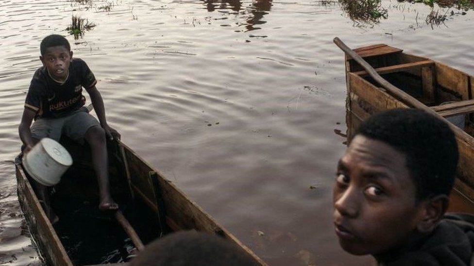 People in Madagascar on a boat after flooding