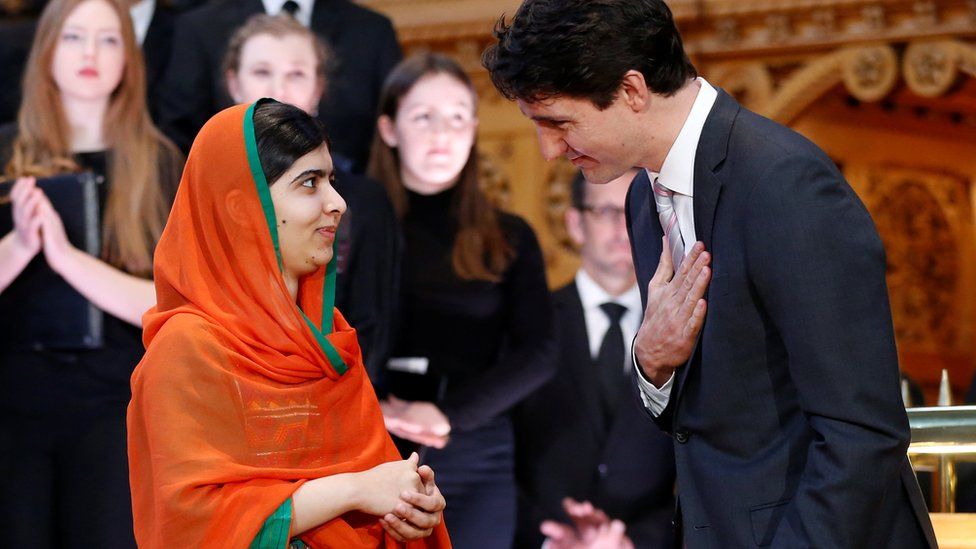 Prime Minister Justin Trudeau (R) gestures towards Pakistani Nobel Peace Prize laureate Malala Yousafzai after presenting her with honorary Canadian citizenship during a ceremony in the Library of Parliament on Parliament Hill in Ottawa, Ontario, Canada, April 12, 2017.