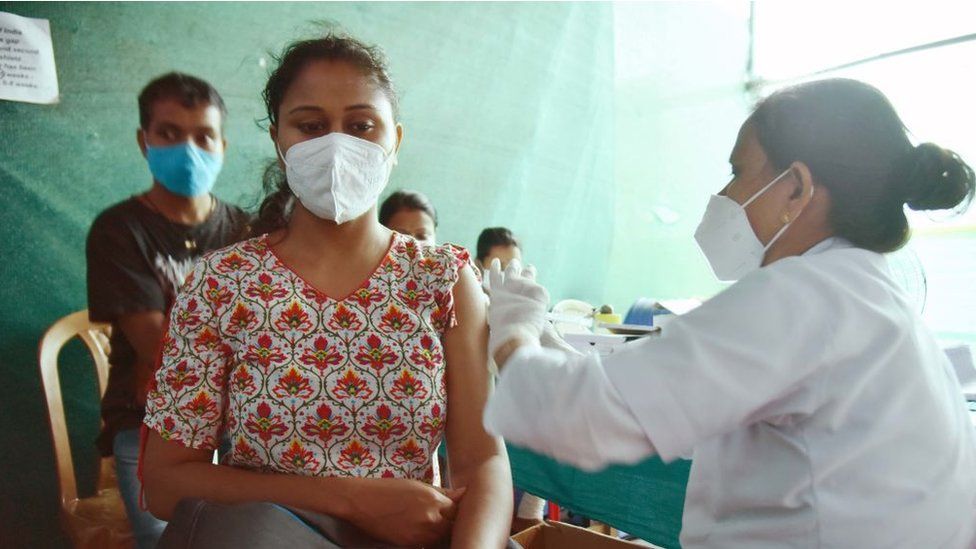 A health worker vaccinates a women in Guwahati, India