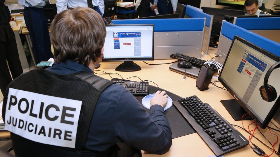French police officers work at the headquarters of the Pharos reporting platform against cyber criminality