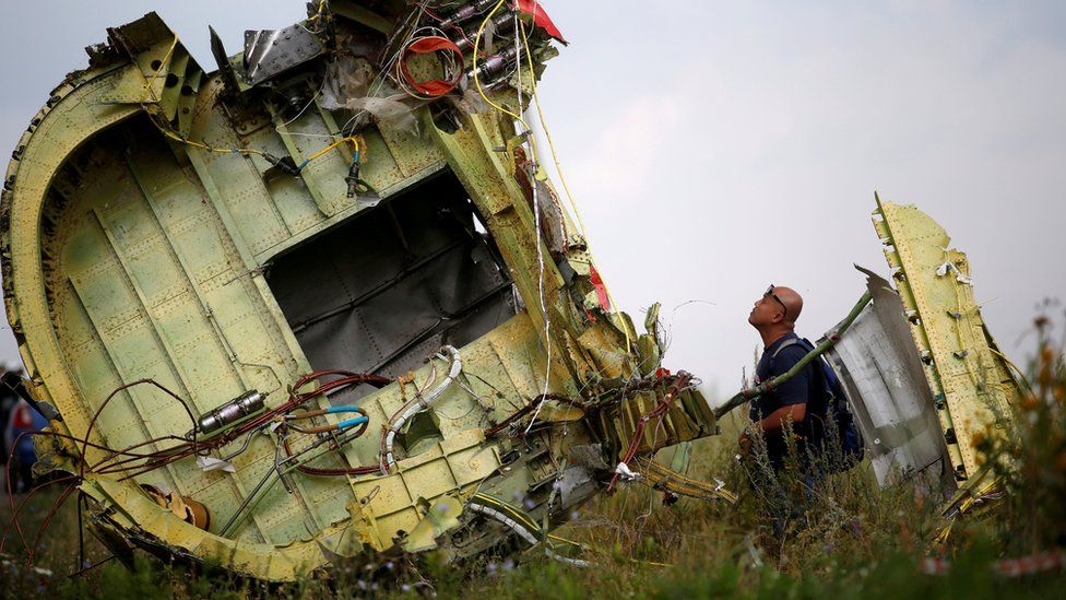 An investigator inspects the wreckage of flight MH17