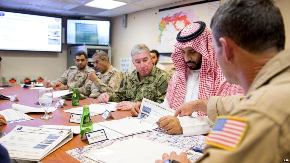 Saudi deputy crown prince and Minister of Defence Mohammed bin Salman (2nd from R) attending a meeting with US Navy officers during a visit to the USS Theodore Roosevelt (8 July 2015)