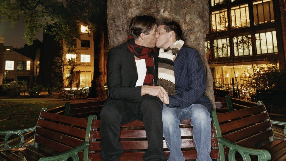 Gay couple kissing in Soho