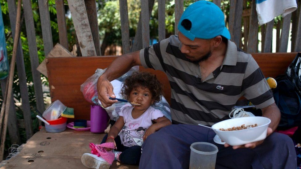 Venezuelan migrant feeds his child on the street in Boa Vista, 30 August 2018