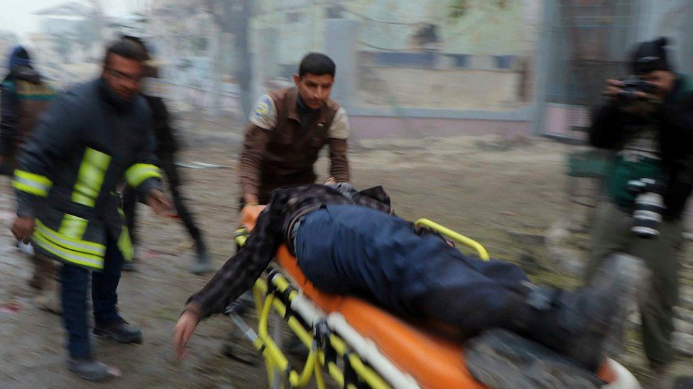 Photograph published by Syria Civil Defence showing man being taken away on a stretcher after a reported government artillery strike on the rebel-held Jubb al-Qubbeh district of Aleppo (30 November 2016)